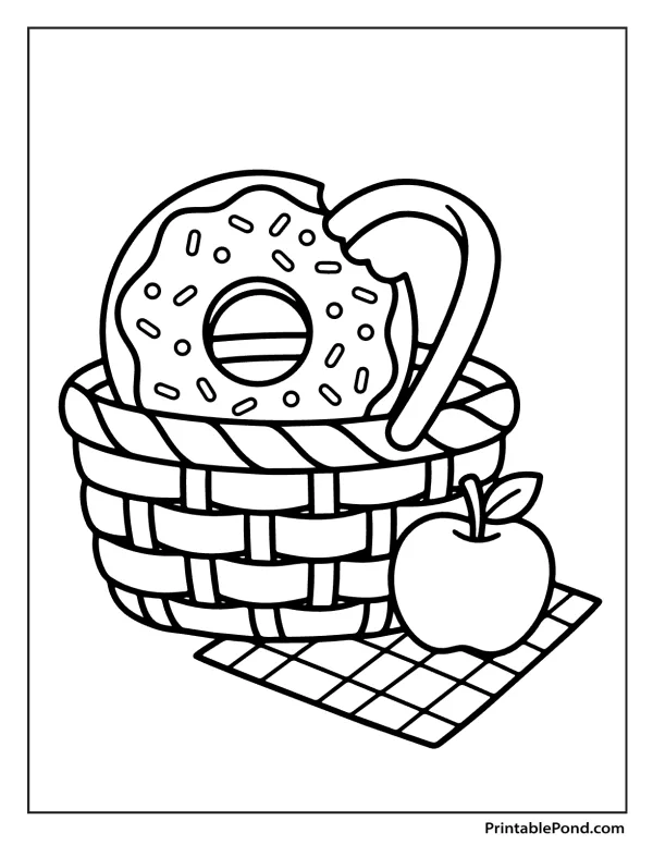 Outline of a donut with sprinkles in a woven picnic basket next to an apple on a checkered cloth.